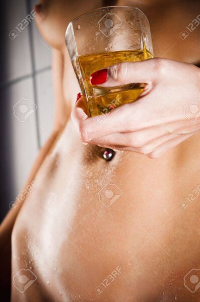 14933386 wet sexy body of a nude young girl and a glass of whiskey closeup